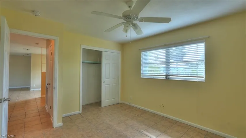 Room featuring ceramic tile flooring, a ceiling fan with light fixture, and a window with blinds