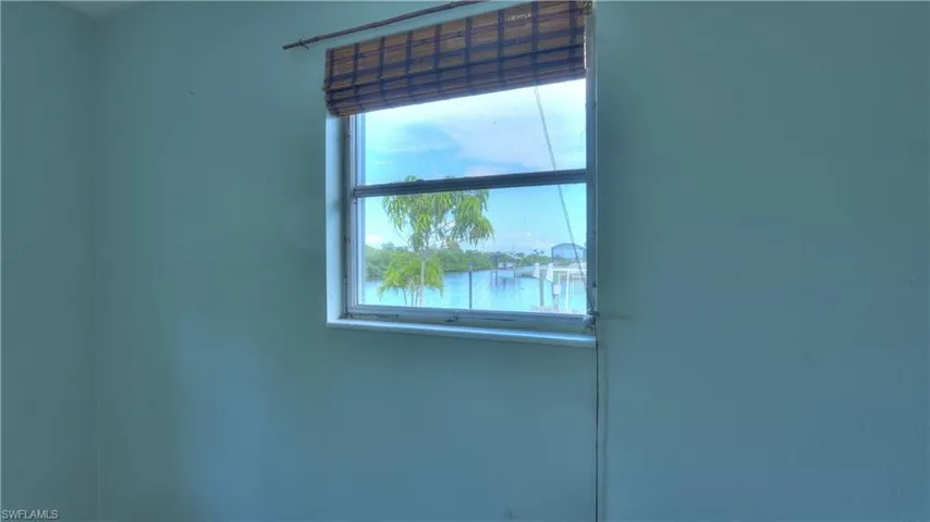 Window featuring a woven wood shade and water views with boat docks