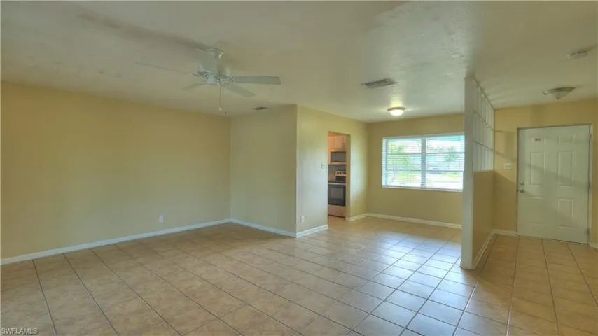 Spacious interior featuring tile flooring, neutral wall tones, and a ceiling fan
