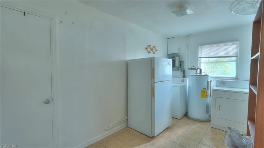 Utility space featuring a window, tile flooring, and built-in shelving
