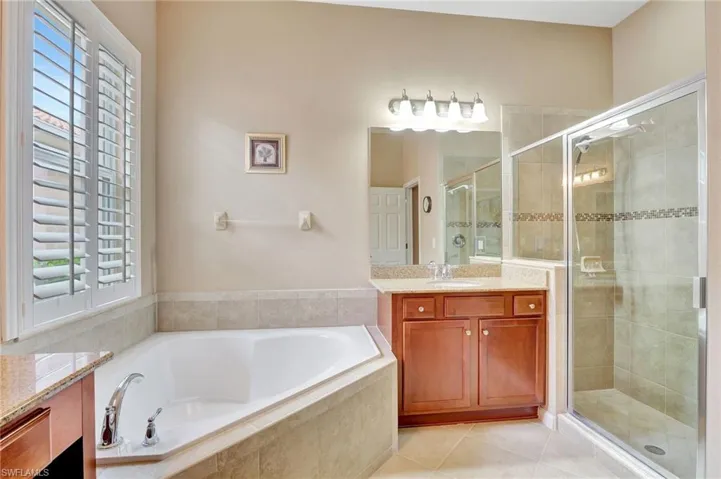 Bathroom featuring tile flooring, oversized vanity, and independent shower and bath