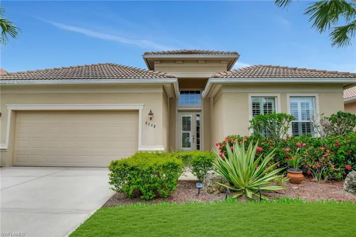 Mediterranean / spanish-style house with a front lawn and a garage