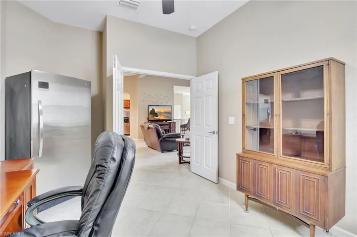 Office/Den space featuring a towering ceiling, light tile flooring, and ceiling fan