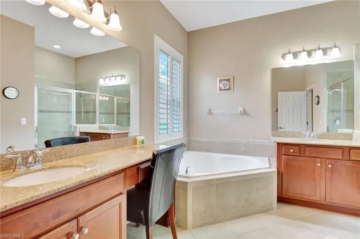 Bathroom with tile flooring, separate shower and tub, double sink, and large vanity