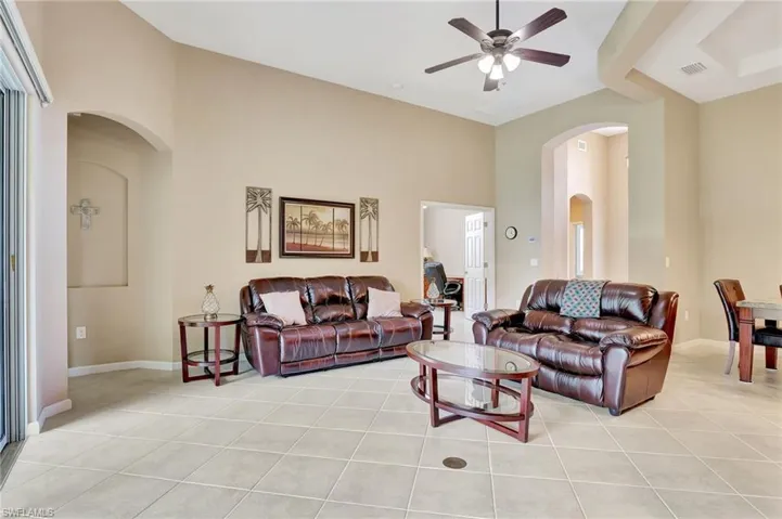 Tiled living room featuring lofted ceiling and ceiling fan