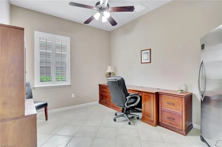 Office/Den space with light tile flooring and ceiling fan