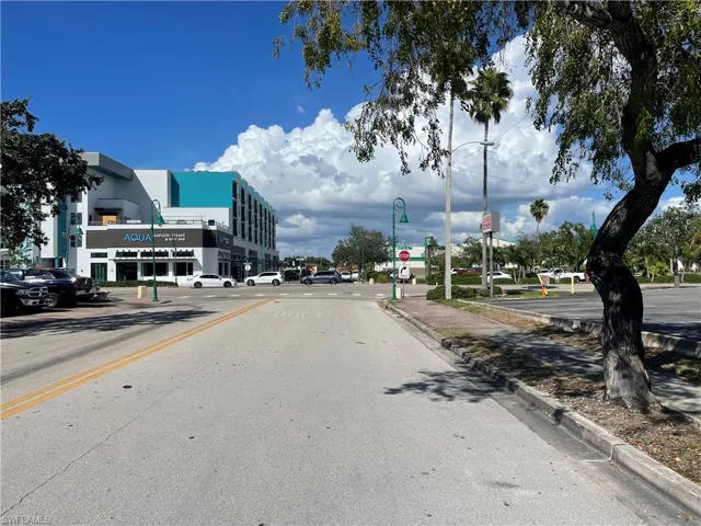 View of asphalt road with traffic signs, sidewalks, and curbs