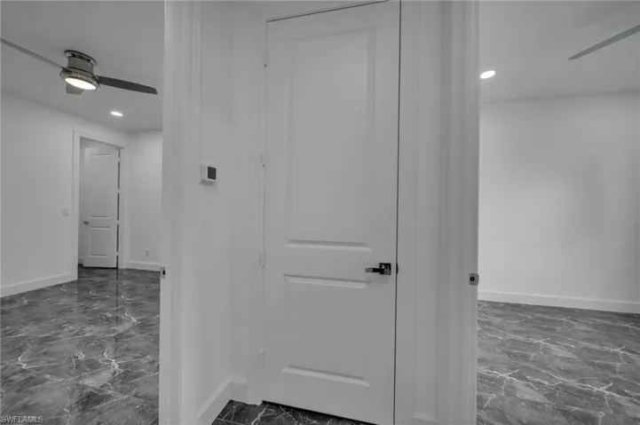 Corridor with recessed lighting, marble finish floor, and baseboards
