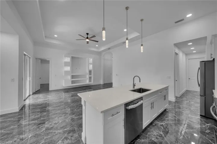 Kitchen with stainless steel appliances, a sink, visible vents, marble finish floor, and a raised ceiling