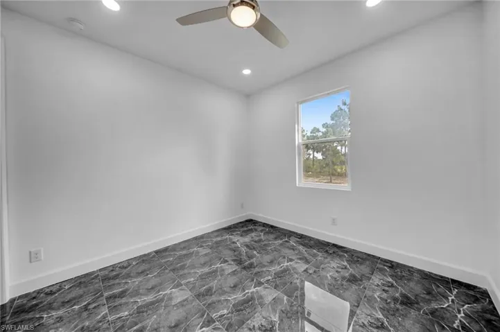 Spare room with ceiling fan, baseboards, and recessed lighting
