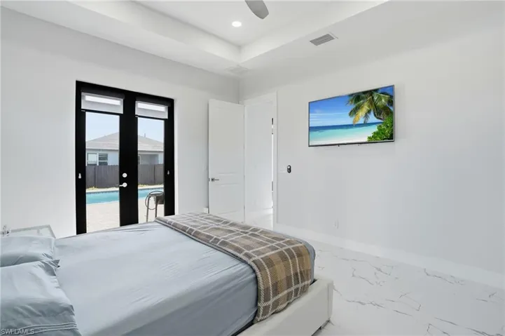 Bedroom with access to outside, ceiling fan, marble look tiles, recessed lighting, and french doors