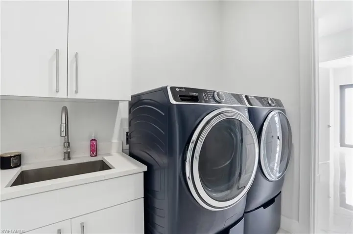 Laundry area with cabinet space and washer and clothes dryer