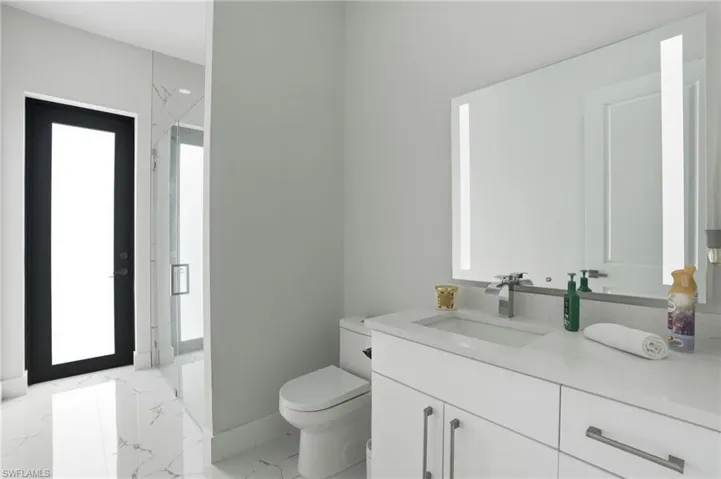 Full bathroom with vanity, light marble finish flooring, and a marble finish shower