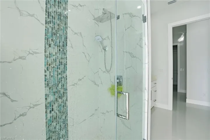 Full bathroom with a marble finish shower and vanity