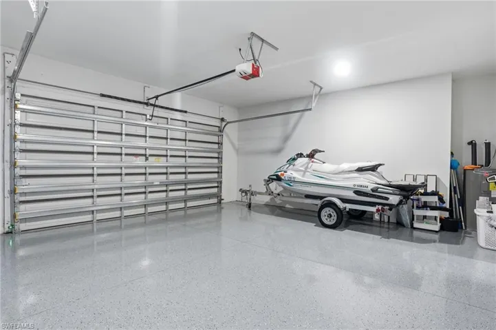 Garage featuring water heater and a garage door opener