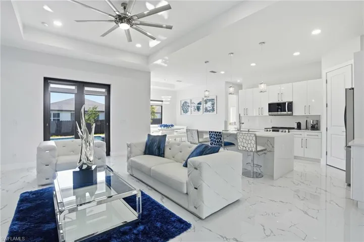 Living room featuring light marble finish flooring, recessed lighting, and a ceiling fan