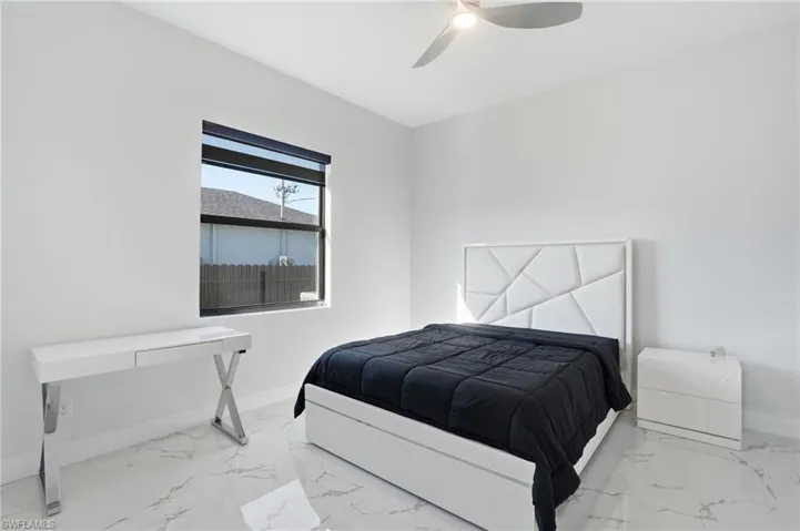Bedroom with light marble finish flooring and a ceiling fan