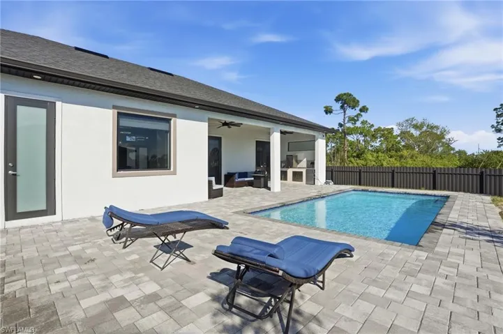 View of pool with patio surround and a fenced backyard