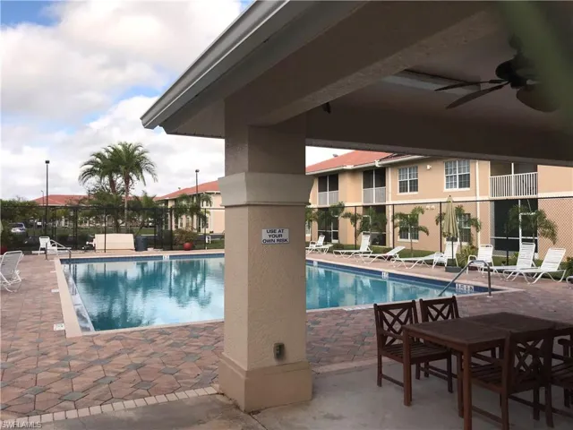 Community pool with a patio area and a ceiling fan