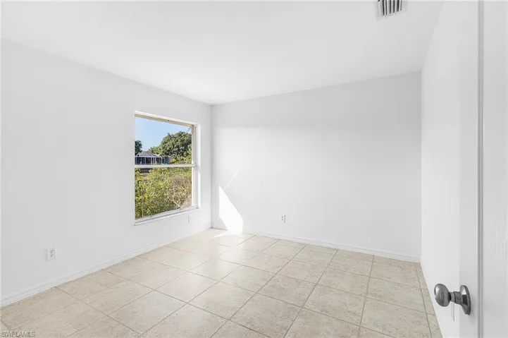 Spare room with baseboards and light tile patterned flooring