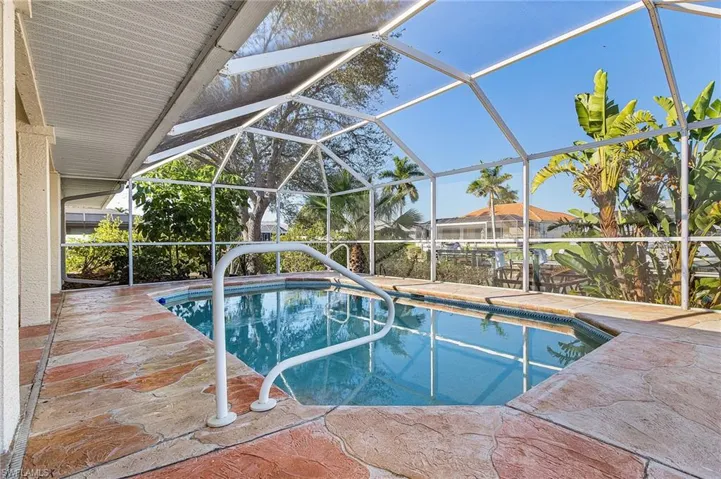 Outdoor pool with a lanai, a sunroom, and a patio