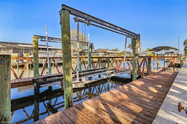 Dock area featuring boat lift and a water view