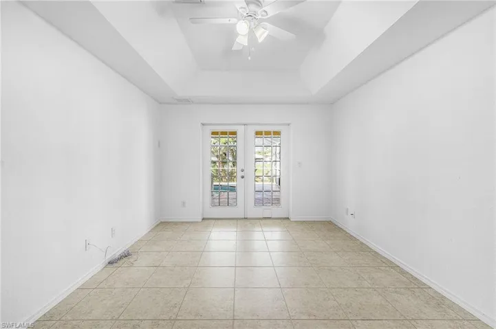 Empty room with french doors, a ceiling fan, and light tile patterned floors