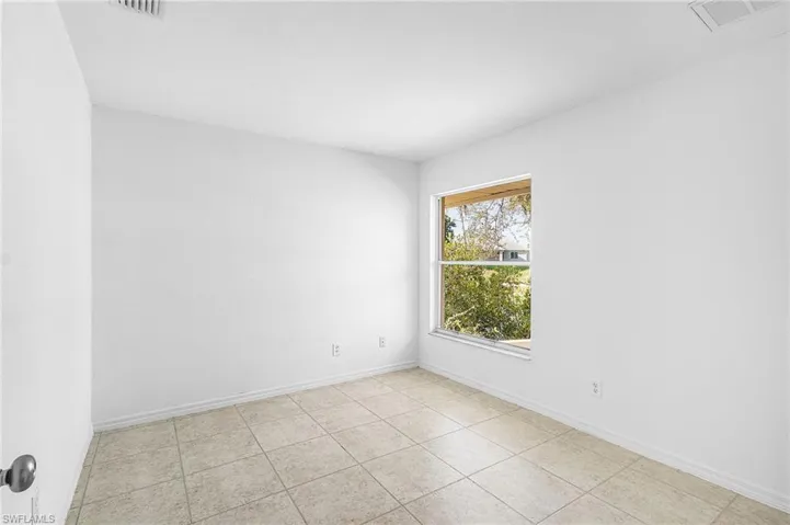 Unfurnished room with light tile patterned floors