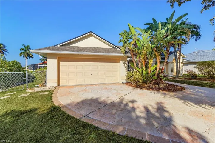 View of front of house with stucco siding, driveway, a garage, and a shingled roof