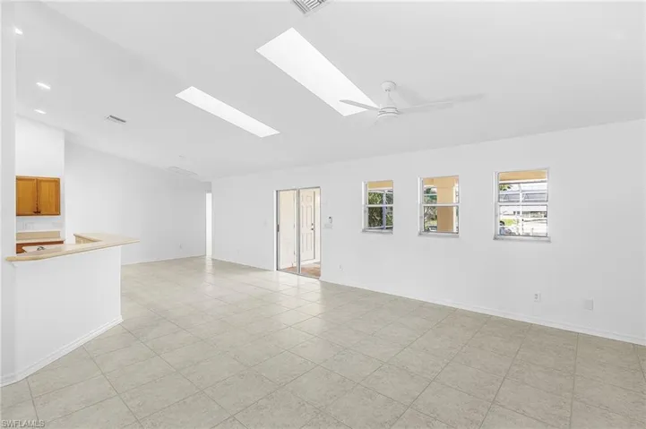 Unfurnished room featuring a skylight, vaulted ceiling, and ceiling fan