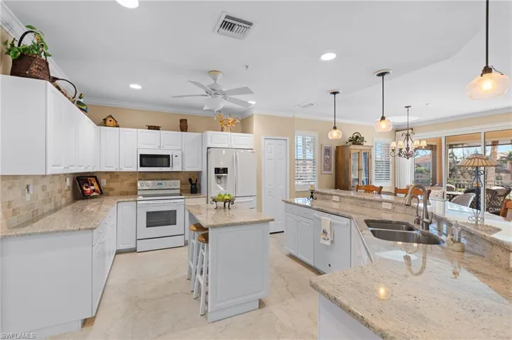 Kitchen featuring white appliances, marble finish floor, a sink, a large island, and visible vents