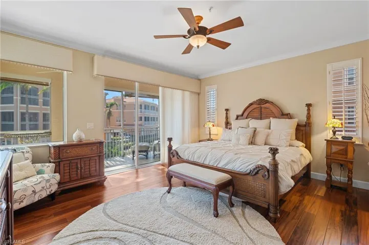 Bedroom with wood-type flooring, crown molding, and access to exterior