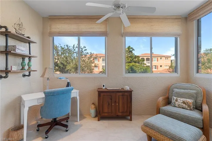 Home office featuring a ceiling fan, a textured wall, and a healthy amount of sunlight