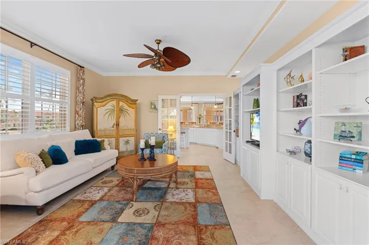 Living area featuring a ceiling fan and ornamental molding