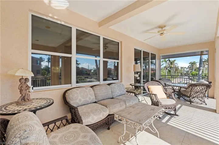 Sunroom featuring tile patterned floors, a textured wall, outdoor lounge area, and ceiling fan