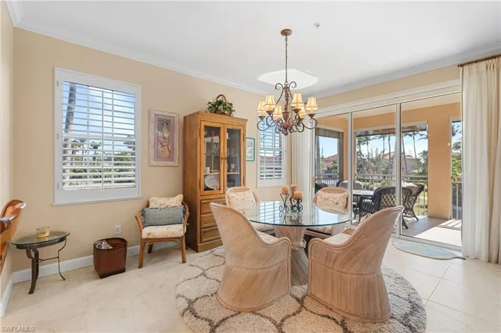 Dining room featuring plenty of natural light, ornamental molding, baseboards, and a chandelier
