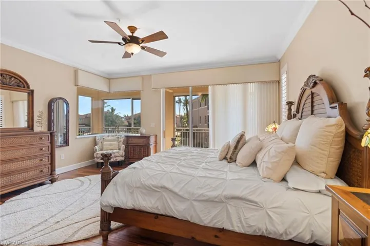 Bedroom featuring crown molding, a ceiling fan, wood finished floors, access to outside, and baseboards