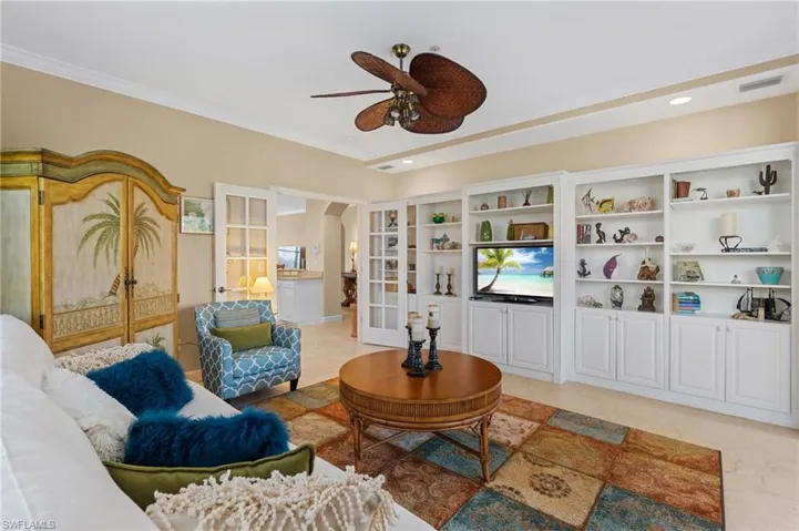 Living room featuring visible vents, ceiling fan, ornamental molding, arched walkways, and french doors