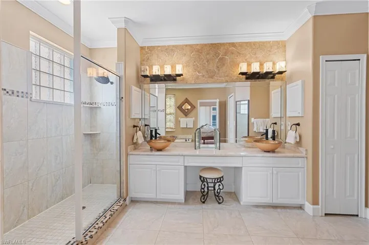 Bathroom featuring a sink, ornamental molding, and walk in shower