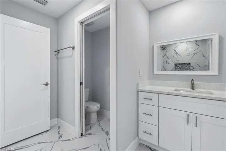 Bathroom featuring tile flooring, vanity, and toilet