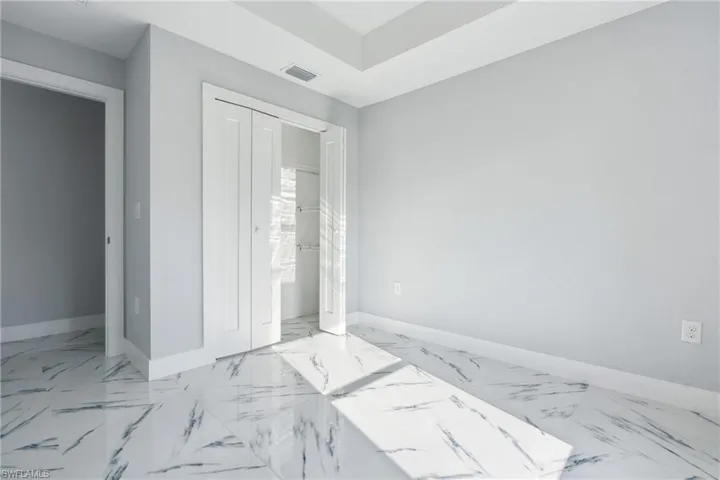 Unfurnished bedroom featuring a closet and light tile floors