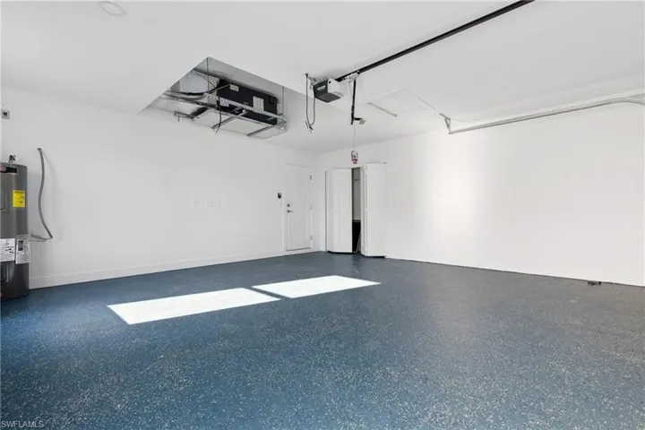 Garage featuring a garage door opener and water heater
