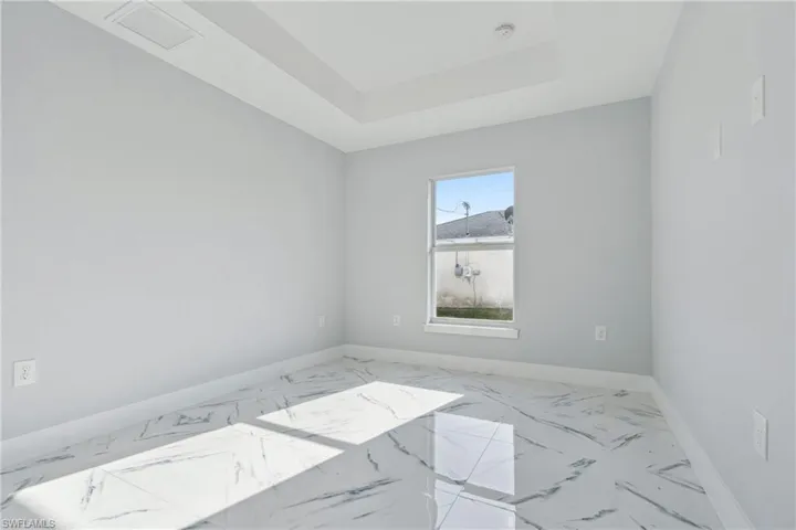 Spare room featuring tile floors and a tray ceiling