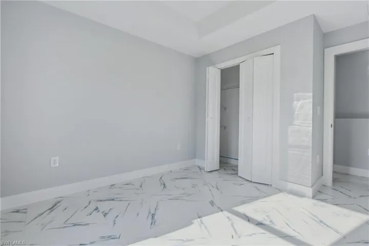 Bedroom featuring a closet and light tile flooring