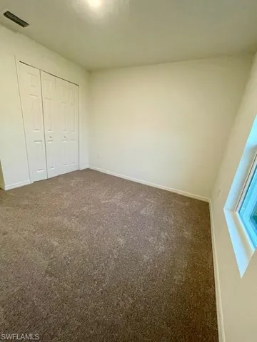Unfurnished bedroom featuring carpet and a closet