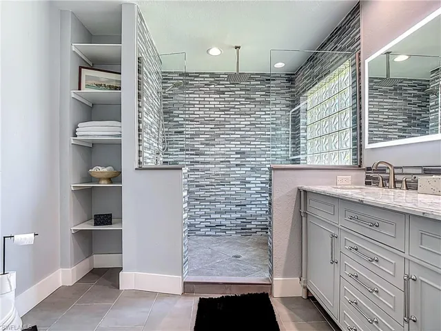 Full bath featuring vanity, a walk in shower, and recessed lighting