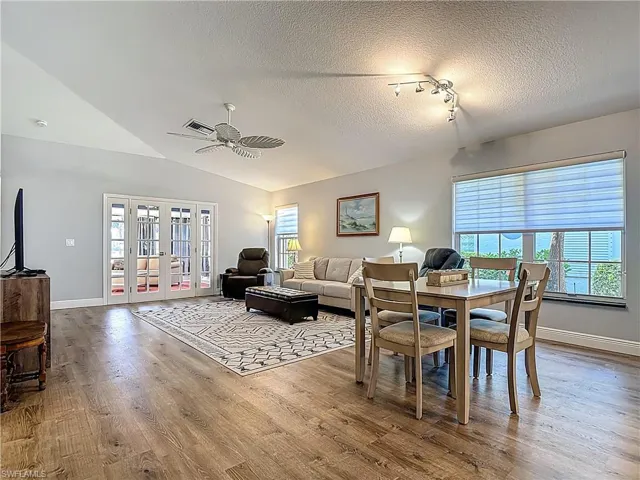 Dining room with a ceiling fan, light wood-style flooring, rail lighting, and french doors