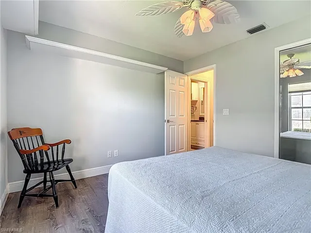 Bedroom with ceiling fan and dark wood-type flooring