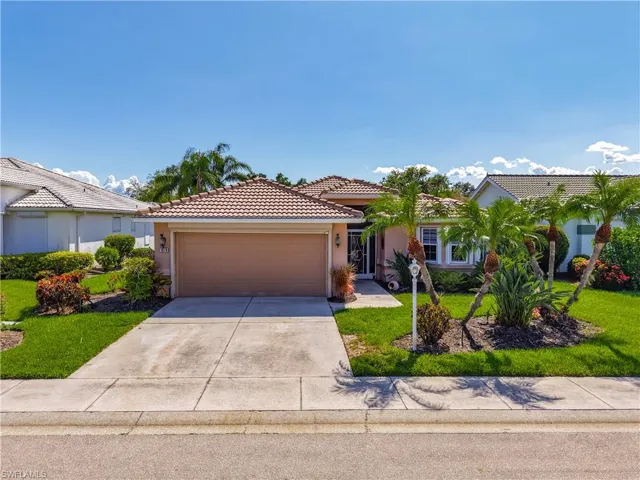 Ranch-style home with driveway, stucco siding, a garage, a tile roof, and a front lawn