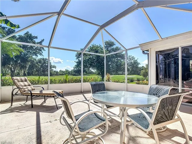 View of patio / terrace featuring outdoor dining area, view of golf course, a sunroom, and a lanai